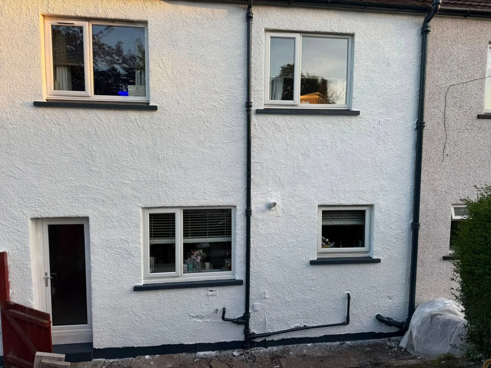 Completed exterior painting with clean white walls and charcoal details